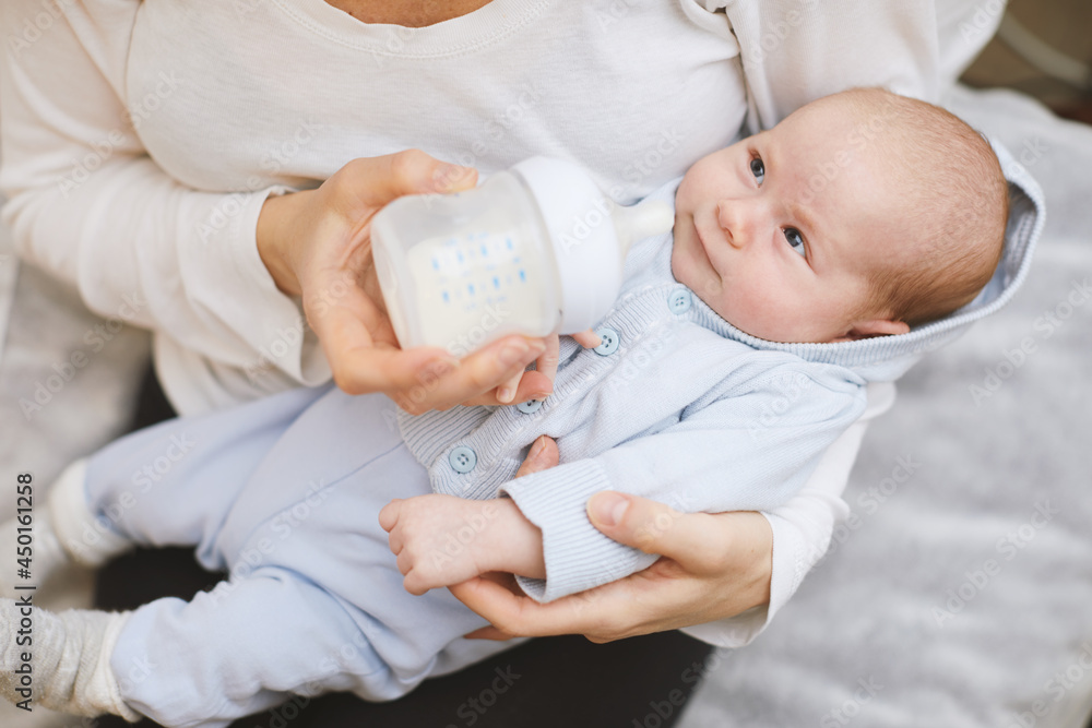 Baby eats milk from a bottle in leaving room. Baby eats milk from a bottle in leaving room.