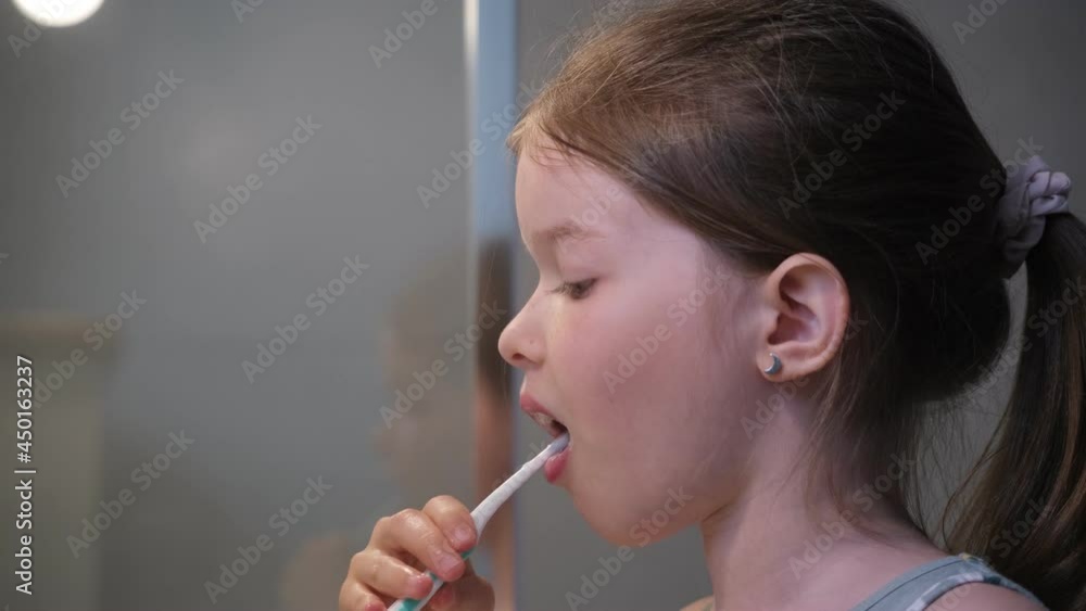 little girl brushing her teeth in the bathroom little girl brushing her teeth in the bathroom