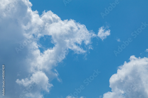 Sunny white high clouds framing bright blue sky, cloudscape background. Skyscape natural heavenly scenery