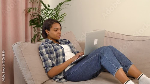 A happy young African-American woman in casual clothes is happy and happy with a big win online. The concept of winning, casino, big win, winning.