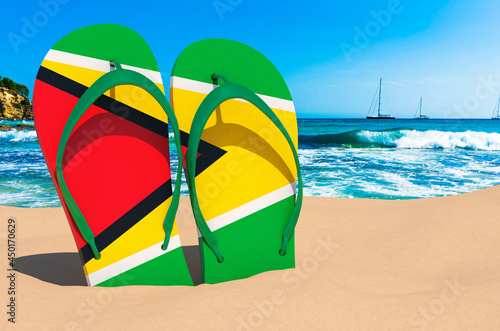 Flip flops with Guyanese flag on the beach. Gayana resorts, vacation, tours, travel packages concept. 3D rendering