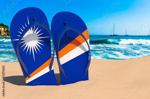 Flip flops with Marshallese flag on the beach. Marshall Islands resorts, vacation, tours, travel packages concept. 3D rendering
