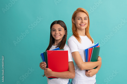 private teacher and child holding copybooks. family help. mother and daughter hold notebook