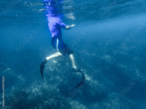 young man swimming underwater with sea bubbles and a blue sea in Mediterranean Sea. Dive among water bubbles under blue sea. swimming man underwater, Swimming in summer and spending a vacation of fun.
