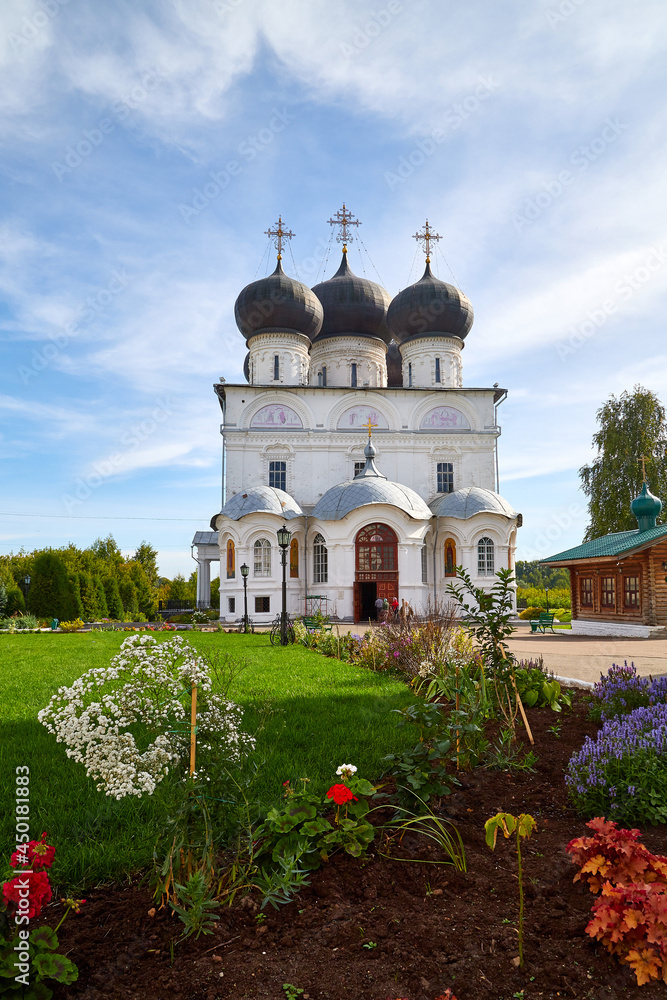 Kirov, Russia - August 26, 2020: The white walls of the Trifonov Monastery. Christian Orthodox Church on the background of a blue sky with clouds