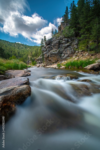BIG THOMPSON RIVER FLOWS OVER RIVER ROCKS NEAR ROCKY MOUNTAIN NP COLORADO