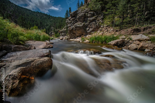 BIG THOMPSON RIVER FLOWS OVER RIVER ROCKS HORIZONTAL NEAR ROCKY MOUNTAIN NP COLORADO