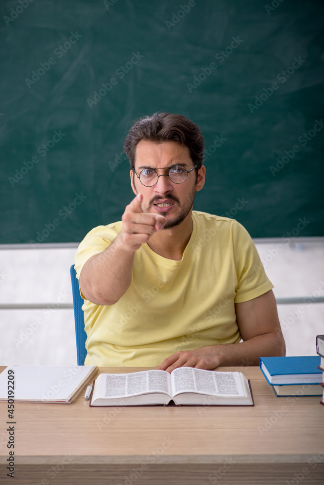 Young male student preparing for exams in the classroom Young male student preparing for exams in the classroom