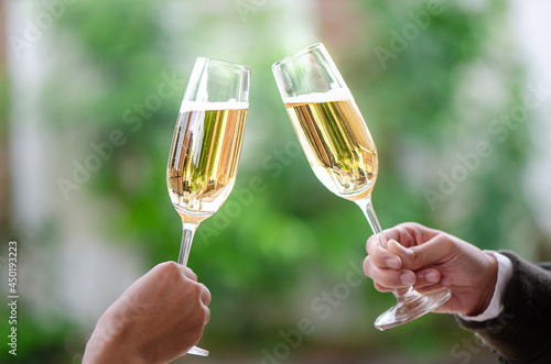 two person holding two glasses of white wine at a celebration dinner
