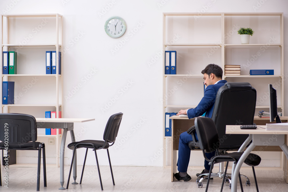 Young male employee and too much work in the office Young male employee and too much work in the office
