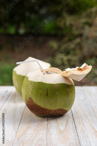 Fresh coconut ready to drink on the wooden table
