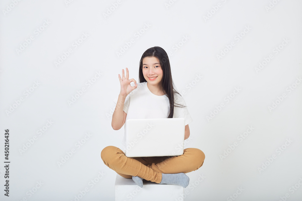 woman sitting using laptop sitting on gray background woman sitting using laptop sitting on gray background