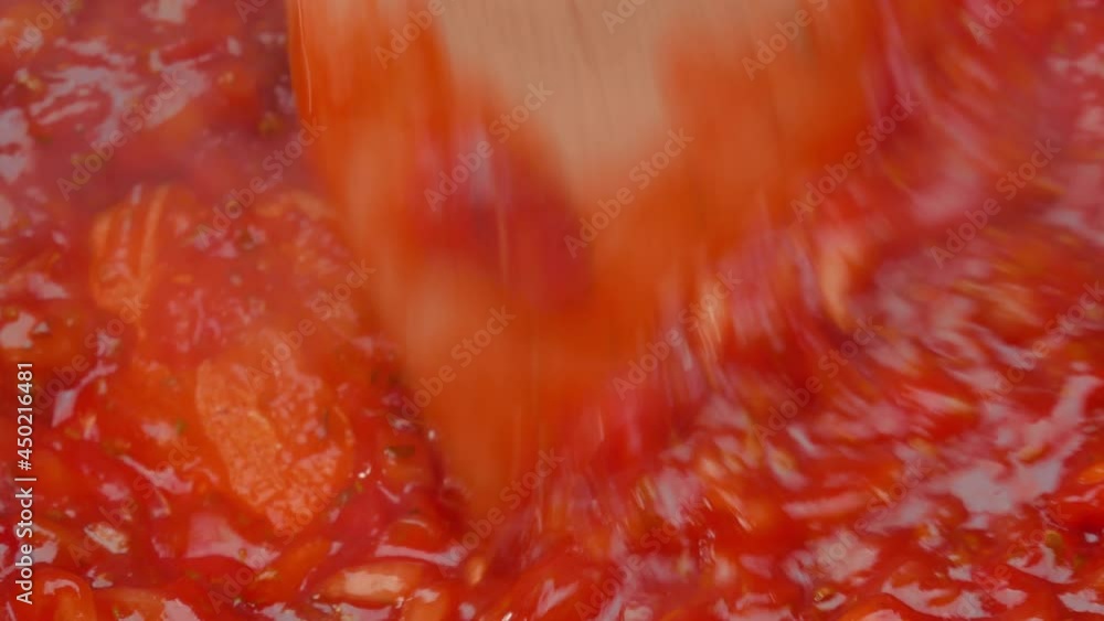 Female hands fries chopped tomatoes and onions making sauce for homemade pizza with healthy ingredients, seasoning with salt and sugar in a saucepan at the kitchen. The process of making pizza. Female hands fries chopped tomatoes and onions making sauce for homemade pizza with healthy ingredients, seasoning with salt and sugar in a saucepan at the kitchen. The process of making pizza.