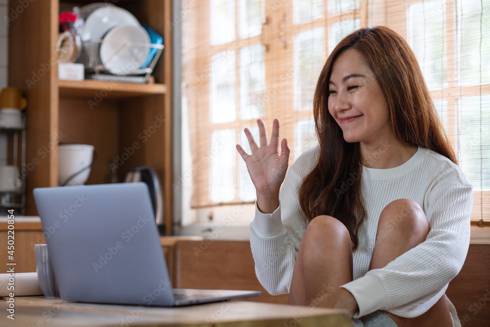 A beautiful young asian woman freelancer using laptop computer for video call and working online at home A beautiful young asian woman freelancer using laptop computer for video call and working online at home