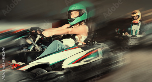 Glad cheerful smiling woman driving sport car for karting in a circuit lap in sport club