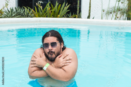 Quadro em tela A silly chubby bearded man wearing shades shivering in the cold pool