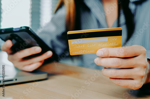 Woman customer hands holding credit card and smartphone for online shopping, online payment concept.	