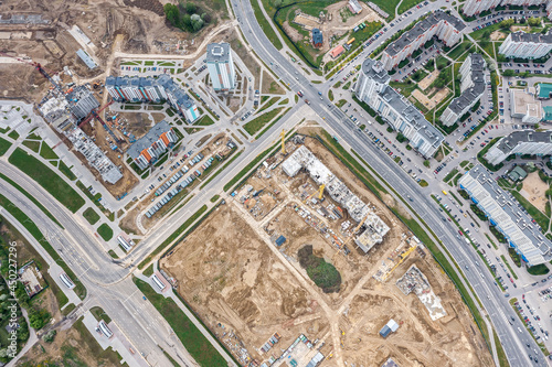 new apartment buildings under construction. development of urban residential district. aerial view from flying drone.