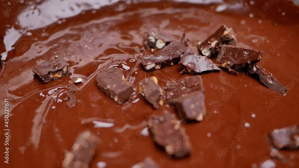 Close up of children hands using a ladle to dissolve the cocoa powder in a stainless steel container with warm water. Process of making homemade Delicious chocolate cookies or brownie cookies. Close up of children hands using a ladle to dissolve the cocoa powder in a stainless steel container with warm water. Process of making homemade Delicious chocolate cookies or brownie cookies.