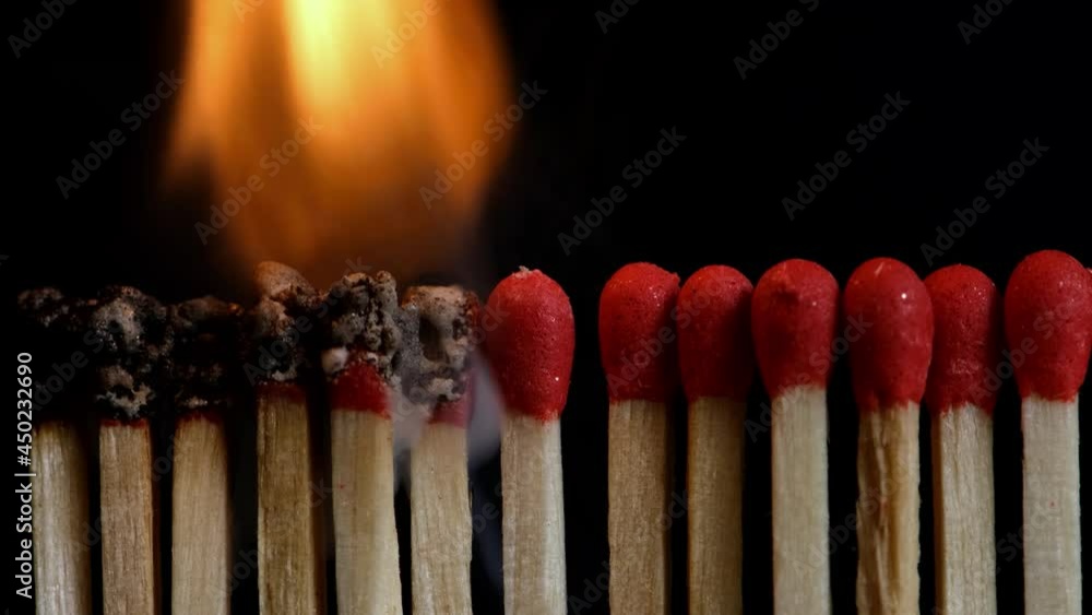 Slow motion of igniting matchsticks against black background.