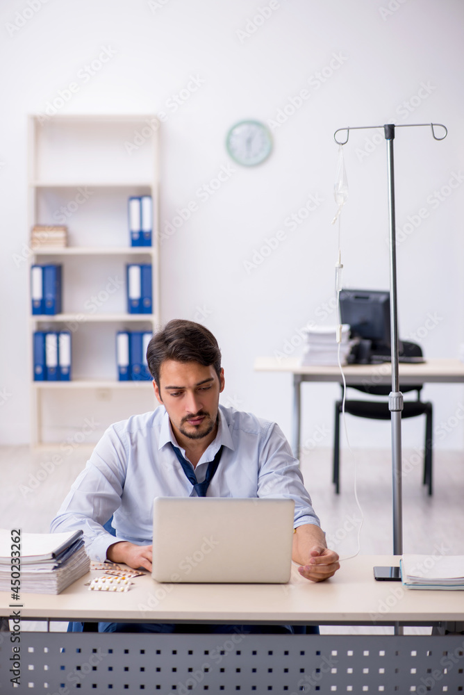Young male employee suffering at workplace