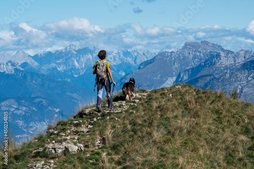 hiker in the mountains with his dog. mountain ridge landscape with blue sky