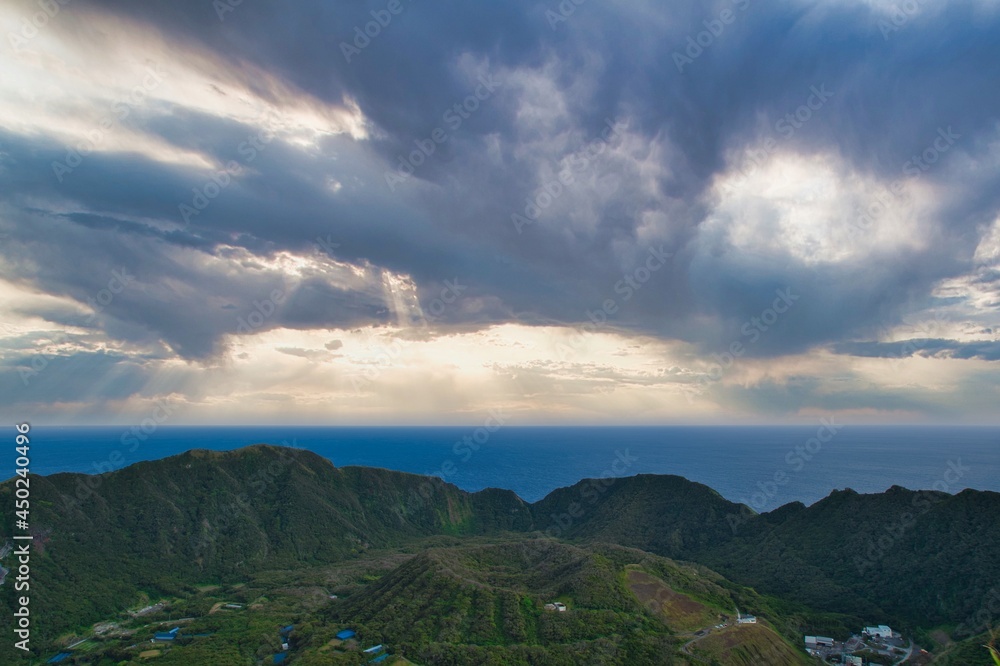 Fototapeta premium The island landscape view of the double caldera with sun lays and clouds in Aogashima, Tokyo