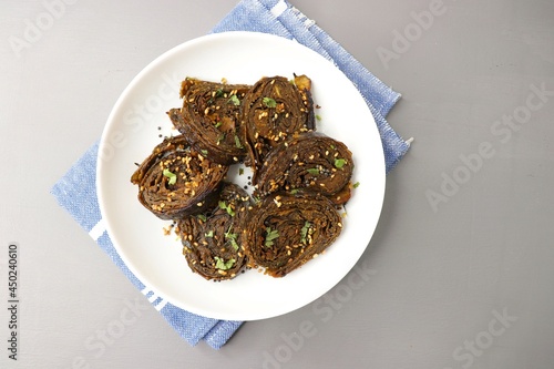 Alu Vadi, Patra, paatra, colocasia leaves roll, Patrode is a popular Indian healthy steamed snack. Garnished with sesame and mustard seeds. copy space. photo