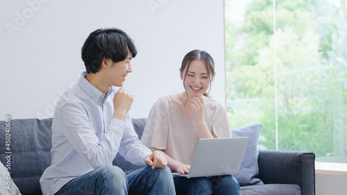 パソコンを使う若い夫婦・カップル