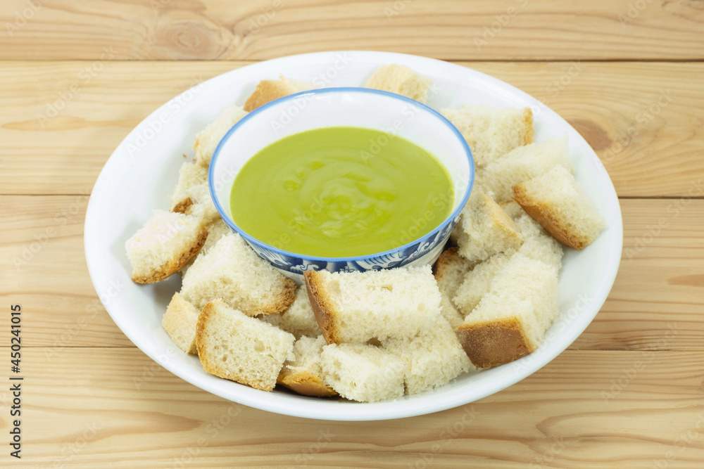 Steamed homemade bread and pandan custard in white ceramic plate on wooden backgroud. Thai dessert. Steamed homemade bread and pandan custard in white ceramic plate on wooden backgroud. Thai dessert.