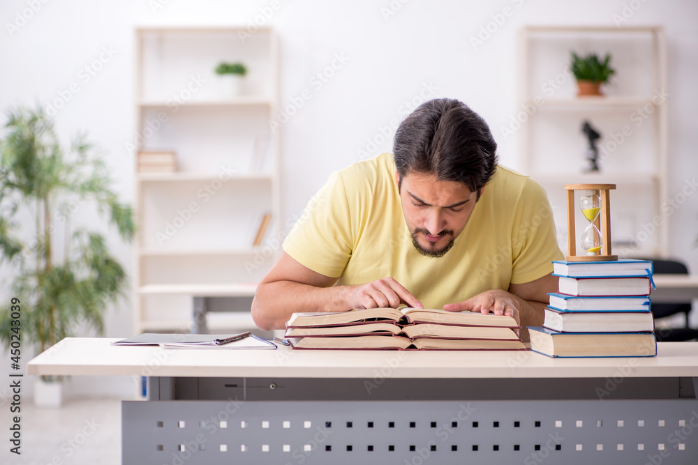 Young male student preparing for exams in time management concep Young male student preparing for exams in time management concep