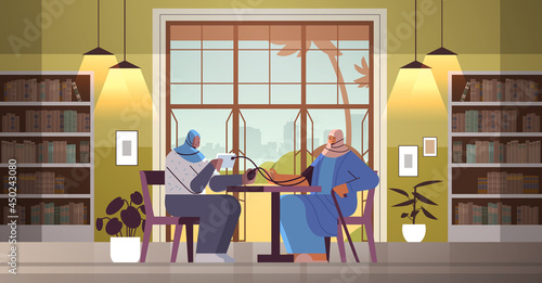 friendly arab nurse or volunteer checking blood pressure to elderly woman patient home care services healthcare
