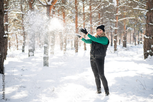 Woman in winter forest surrounded by snowflakes.