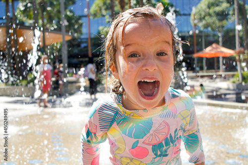 Young girl happily playing in an outdoor water park