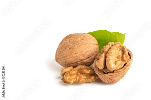 Peeled walnut fruits lie on a white isolated background with green leaves. Walnut in shell. White isolate for design and insertion into the project.