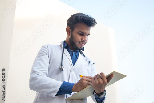 Photography A health worker in Lab Coat Writing a notepad and pen