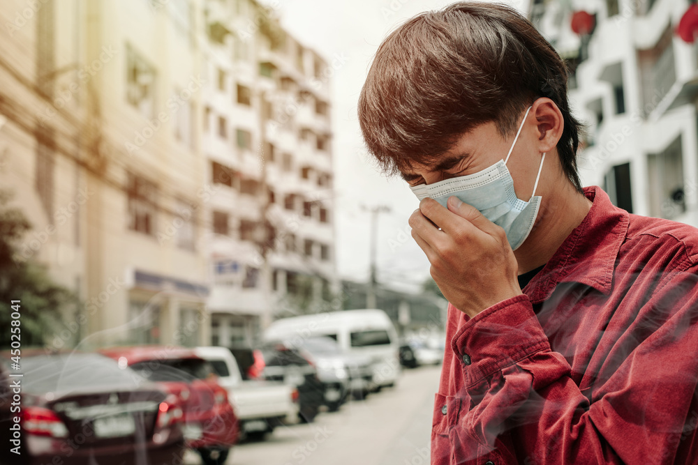Man wearing the respiratory protection mask against air pollution and dust particles exceed the safety limits. Healthcare, environmental, ecology concept. PM2.5