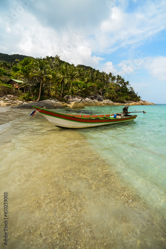 Fishing or Long-tail boat on Koh Phangan Island beach in Thailand, South-East Asia. Crystal clear water and sky on the cost. South Islands are lack of people due to Covid-19 lockdown