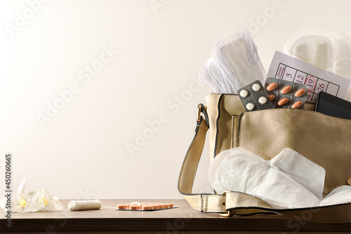 Purse with menstrual products on wooden table cloeup isolated background photo