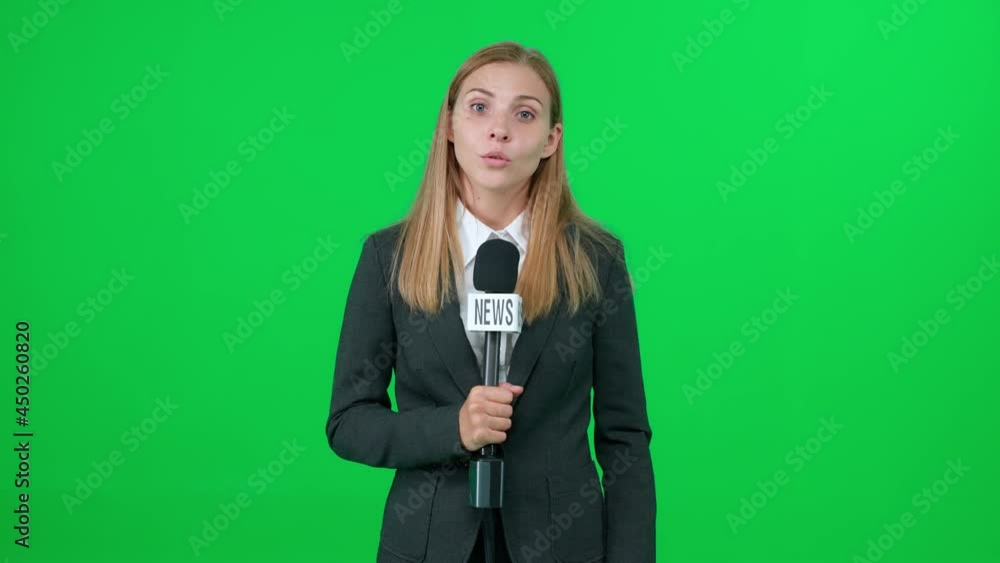 Breaking news, caucasian female news reporter speaks into a microphone on a green background and looks into the camera, template for TV news agencies, woman journalist at work, chromakey. Breaking news, caucasian female news reporter speaks into a microphone on a green background and looks into the camera, template for TV news agencies, woman journalist at work, chromakey.