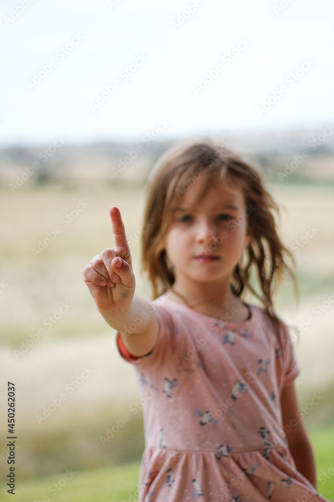 Young girl in pink dress pointing skyward Young girl in pink dress pointing skyward