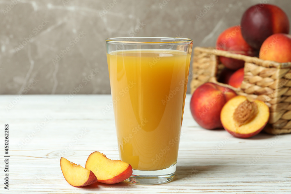 Glass of peach juice and peach fruits on white wooden table Glass of peach juice and peach fruits on white wooden table
