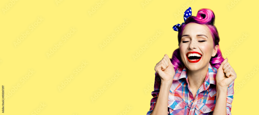 Unbelievable news! Excited surprised, very happy purple red woman. Pin up girl with open mouth and closed eyes with raised hands fists. Retro and vintage concept. Yellow background. Wide image.