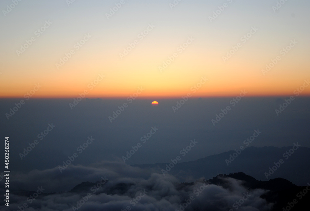 A magnificent view of sunrise turns golden yellow and orange color looks mesmerizing as seen from Sandakphu situated at 12,400 ft altitude in Darjeeling, India. This is the most popular tourist spot o