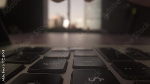 Person Typing on the Laptop Keyboard and press Enter Key  in office background . 4K Extremely Close up macro dolly in shot under the fingers