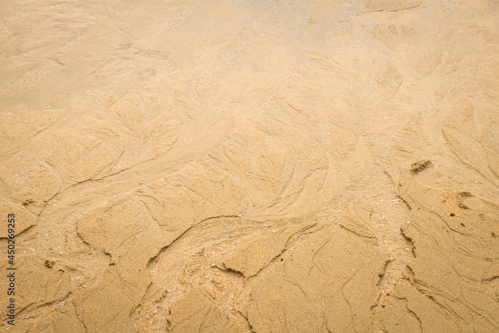 Water erodes the sand on the beach Water erodes the sand on the beach