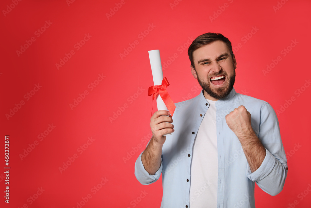 Emotional student with diploma on red background. Space for text Emotional student with diploma on red background. Space for text