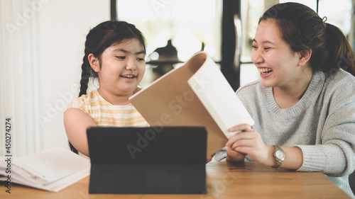 The sisters taught the sisters to do their homework at home and they smiled happily.