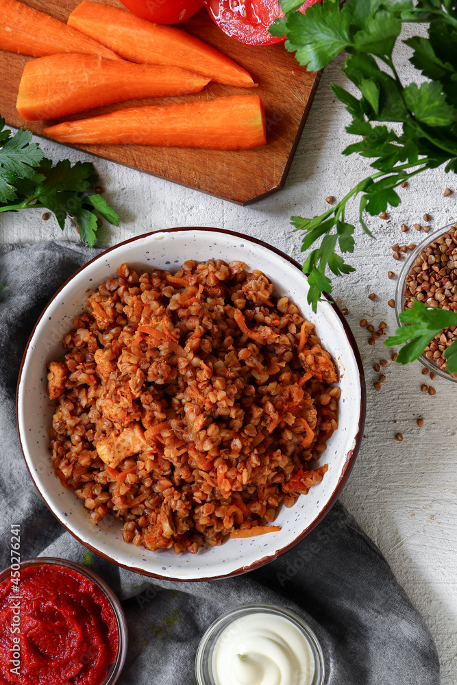 Healthy food concept. Buckwheat porridge with tomato sauce. Top view. Light background. Copy space. Diet lunch. Ingredients. Healthy food concept. Buckwheat porridge with tomato sauce. Top view. Light background. Copy space. Diet lunch. Ingredients.