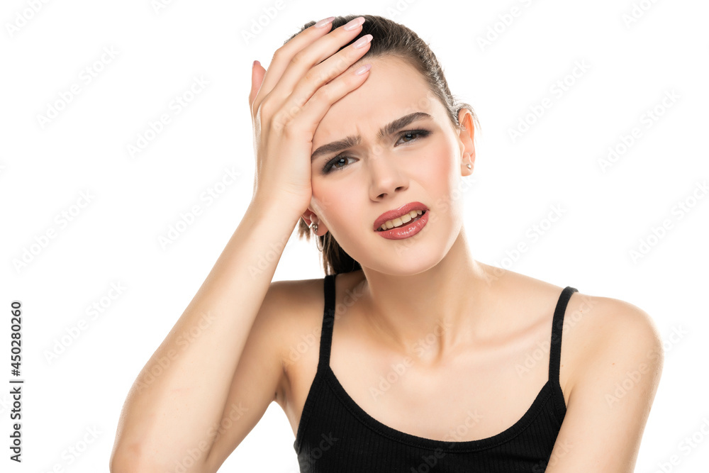 Frustrated brunette teen girl holding hand on forehead Frustrated brunette teen girl holding hand on forehead